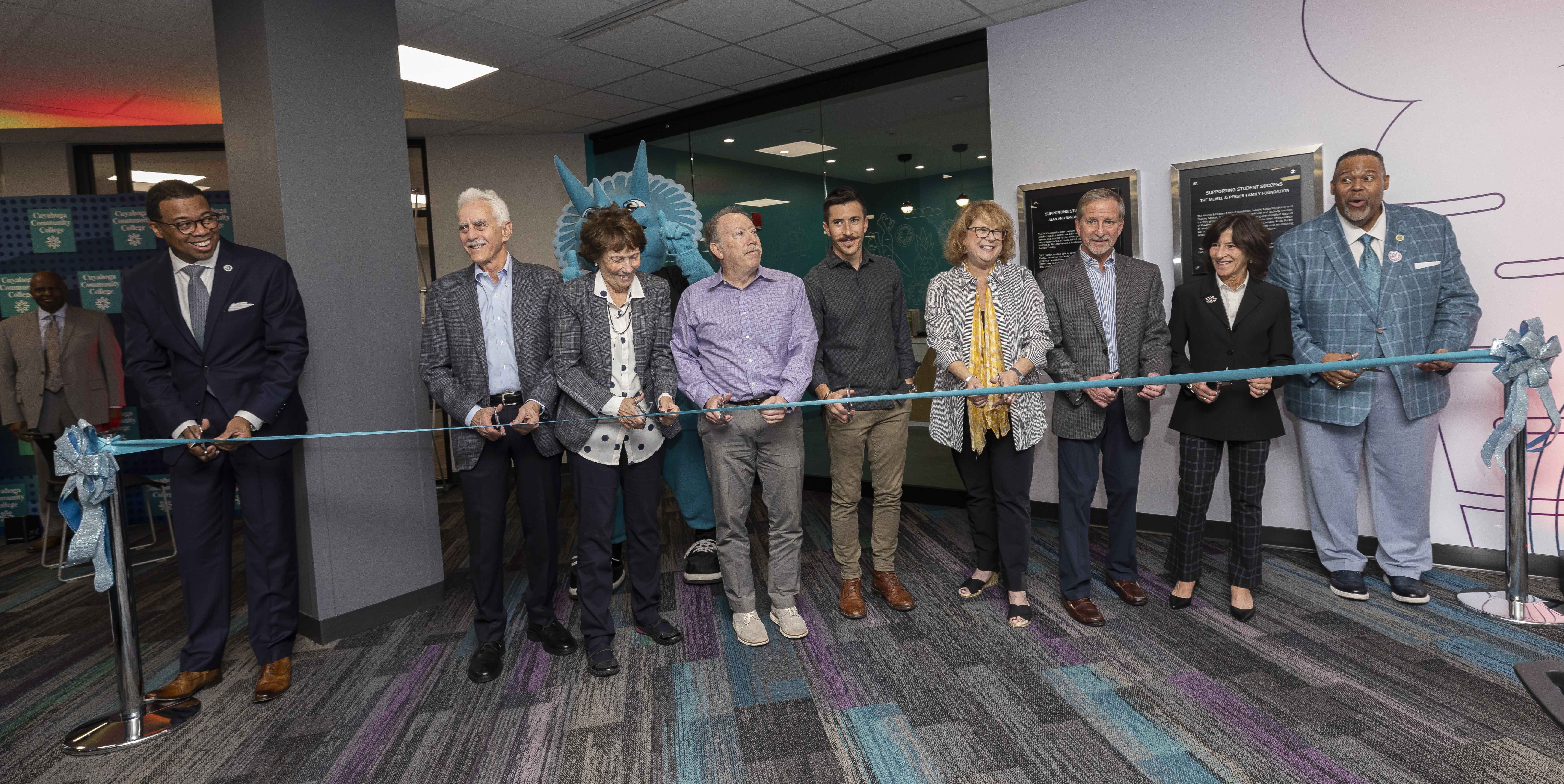 Line of individuals in business attire cutting a ribbon to dedicate the pantry space