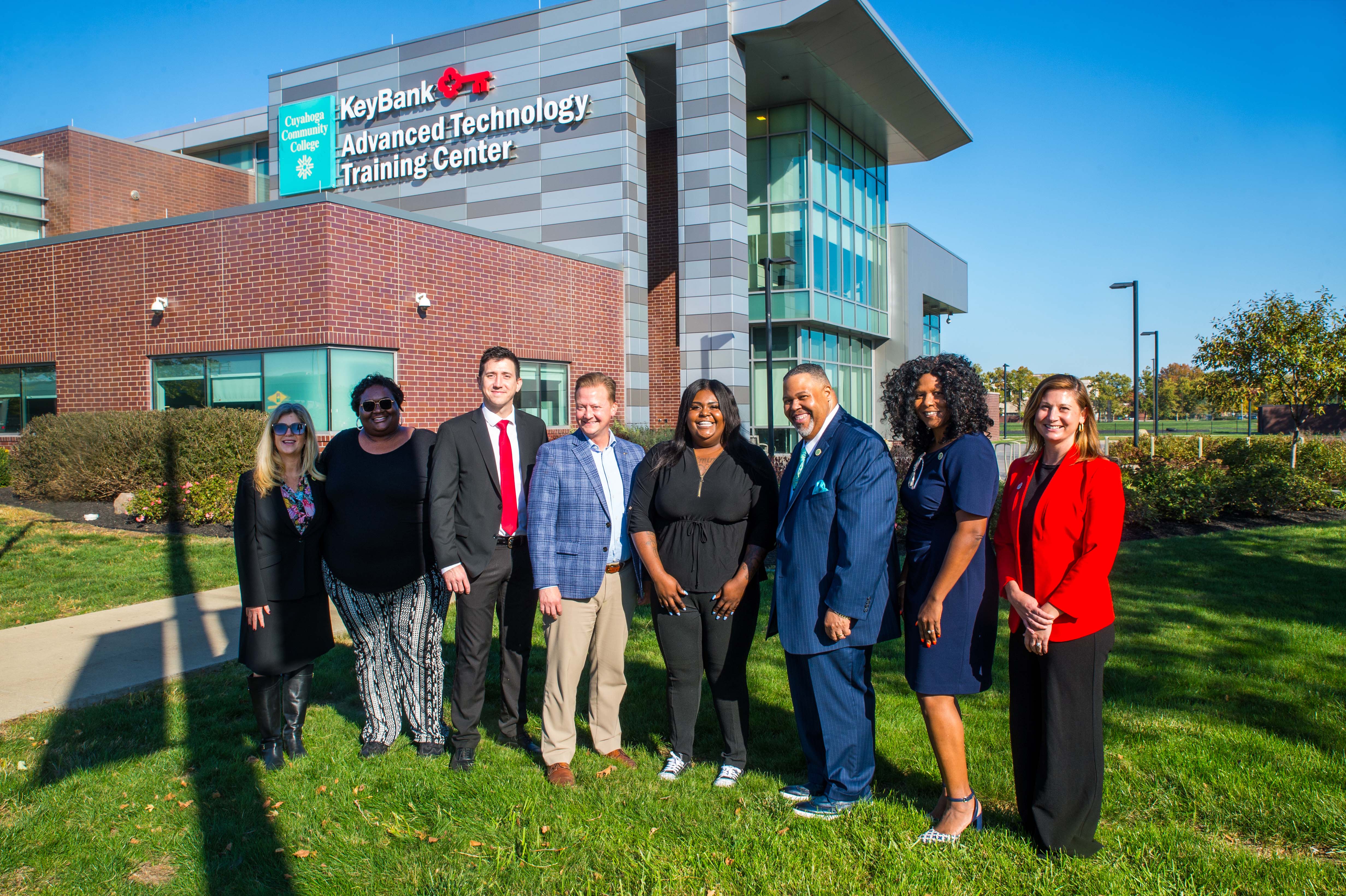 Leadership from KeyBank, Tri-C and Tri-C Foundation in a line standing in front of the KeyBank Advanced Technology Training Center, signage clearly visible. Sunny Fall day.