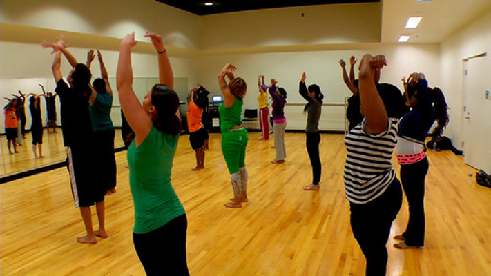 group of dancers reaching upwards in dance studio