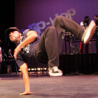 break dancer twisting legs while balancing on one arm