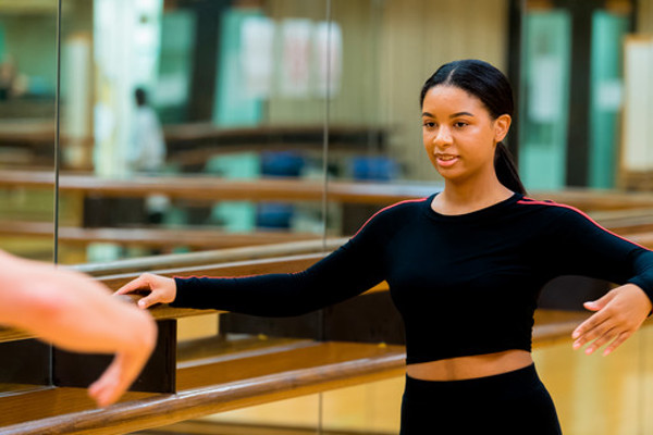 female dancer standing at ballet barre