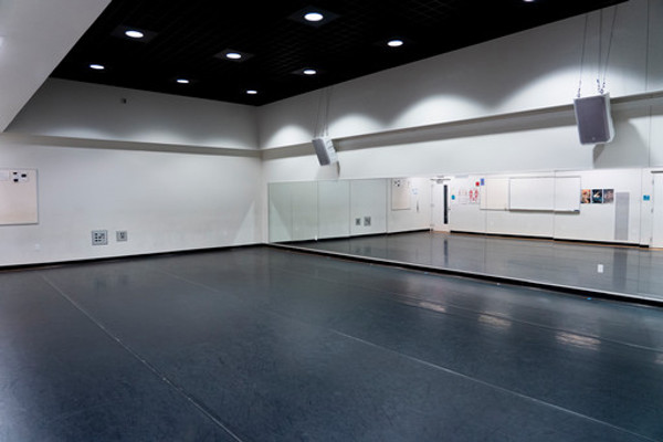 Dance studio 018 with black floor, empty (can see door in mirror)