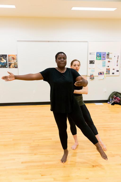 dance student standing in tendu position with teacher behind